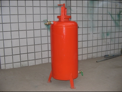 Red upright fertilizer tank with inlet and outlet valves used for fertigation in a greenhouse